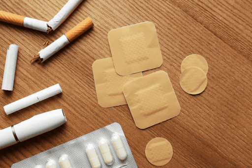 Cigarettes, nicotine patches, and various tobacco products scattered on a wooden table.