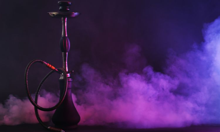Hookah pipe standing upright with colorful purple and pink smoke in the background on a dark surface.