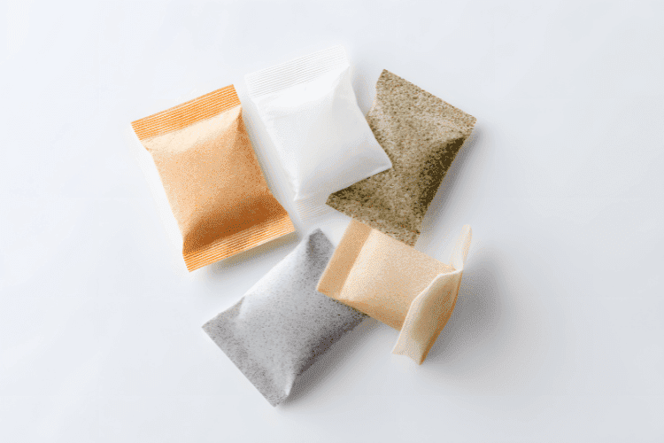 Assorted small sachets containing various powders arranged on a white background.