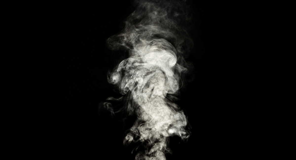 Thick white smoke swirling upward against a black background.