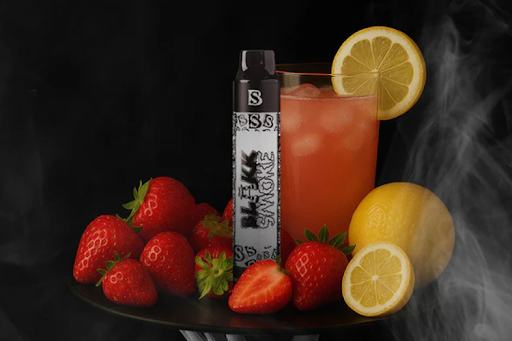 A vibrant glass of juice with lemon slices and strawberries, next to a vape